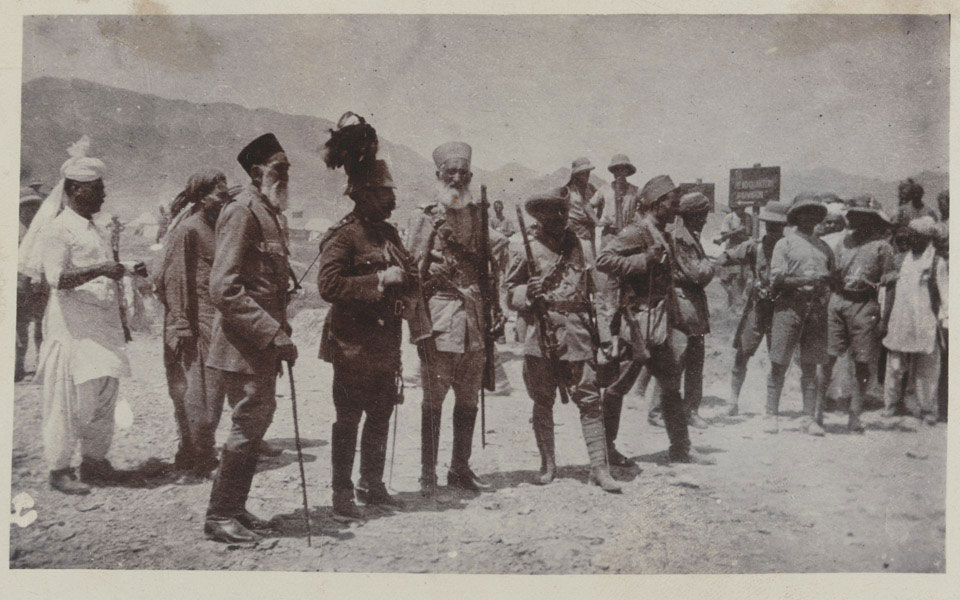 "The Afghan peace delegation while crossing the Torkham border on their way to the Rawalpindi peace conference, 24 July 1919. The tall, bearded man on the left is Ghulam Muhammad Khan Wardak, then Minister of Commerce, while the figure in the centre with a plumed cap is probably Mahmud Tarzi, Minister of Foreign Affairs and head of the delegation.”