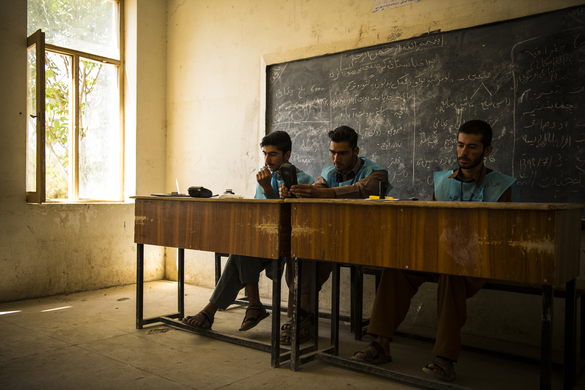 With intermittent fighting and rocket attacks throughout the day, election workers in the Awal Baba school voting centre in Maidan Shahr, had little work to do. Photo: Andrew Quilty, 2019.