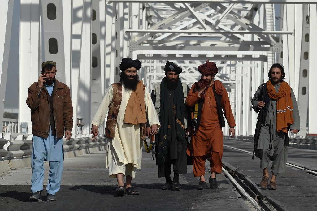 Head of customs for the Hairatan border crossing in Balkh province, Abdul Sattar Rashid (second left), with other Taleban on the Afghanistan-Uzbekistan Friendship Bridge. The Taleban moved swiftly to organise and regularise the collection of customs and taxes as they took power in 2021. Photo: Wakil Kohsar/AFP, 27 October 2021